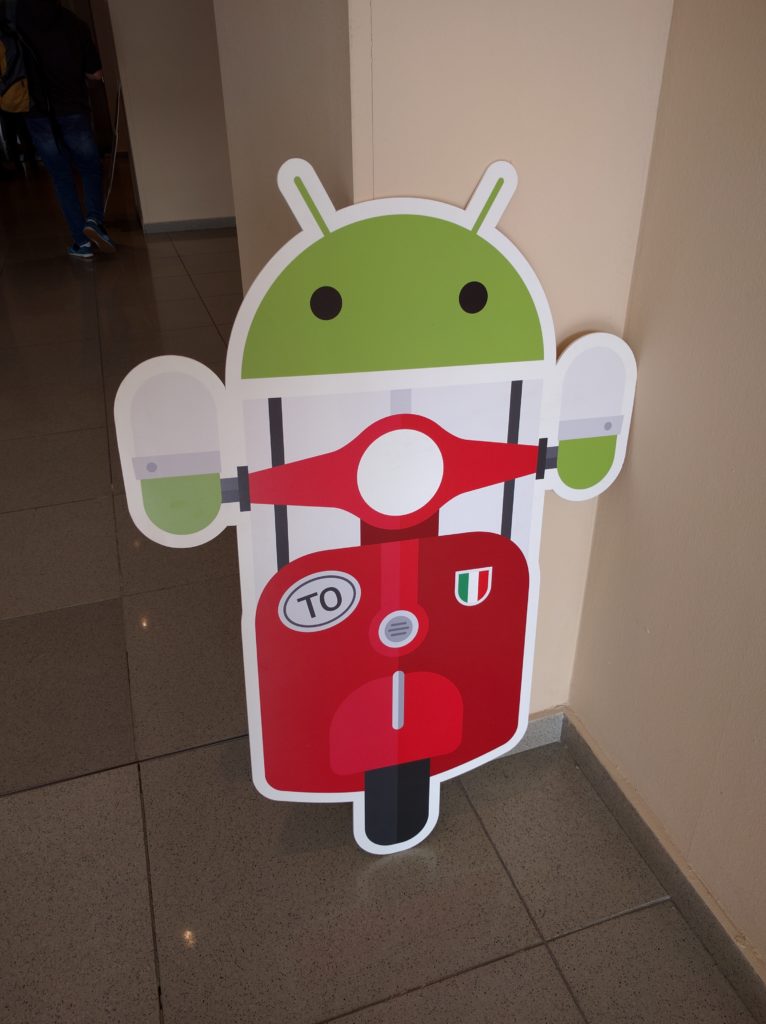 Cardboard cutout of android robot on vespa
