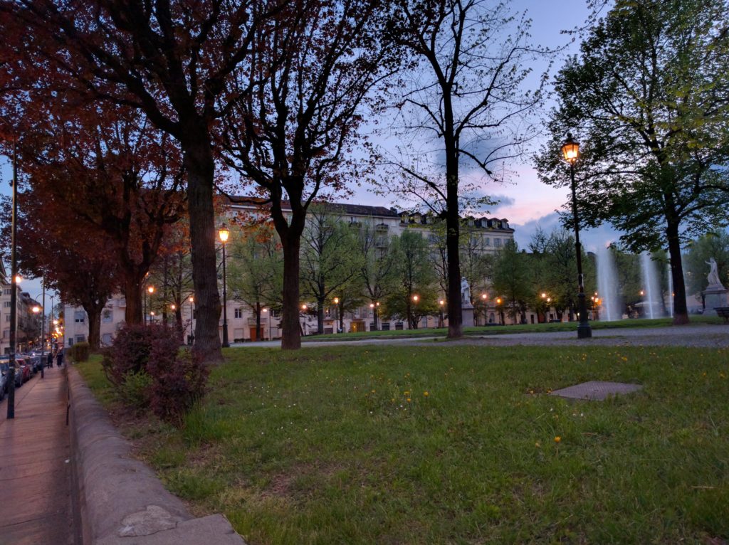 Plaza at dusk, with park and water fountains